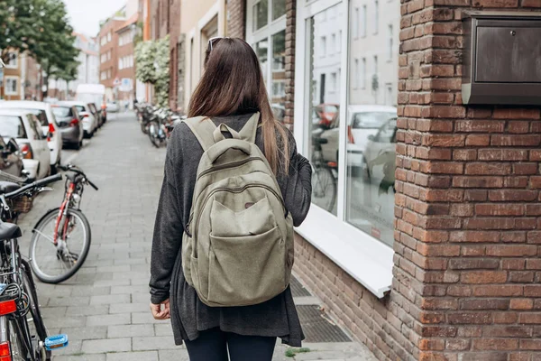 Turista con una mochila está buscando alojamiento en línea reservado en una ciudad desconocida . — Foto de Stock