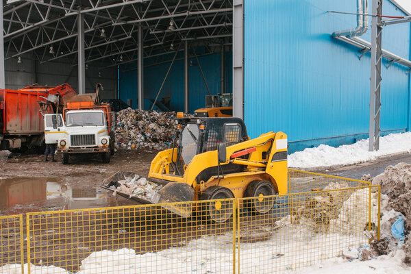 Special trucks work at the landfill site for waste disposal. Technological process. Business for sorting and recycling.