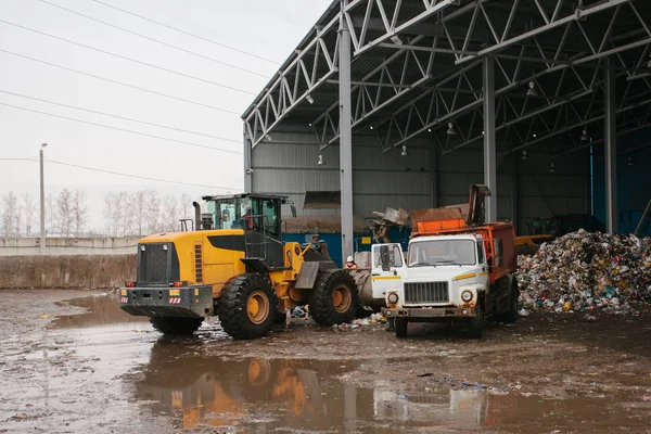 Speciale machines of bulldozer werken op de site van afval lossing in de fabriek voor afvalverwijdering. — Stockfoto