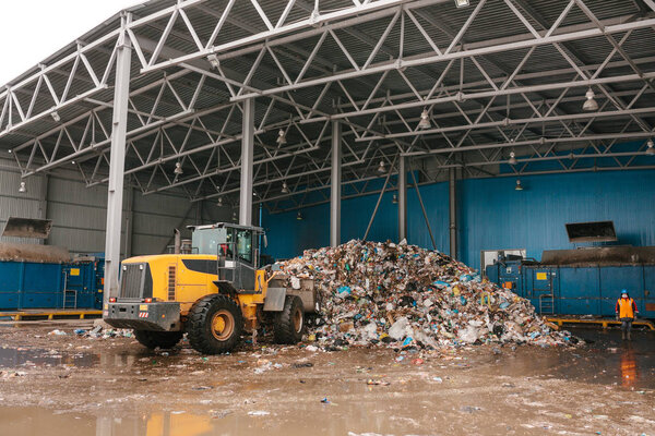 Special machinery or bulldozer work on the site of waste unloading at the plant for waste disposal.
