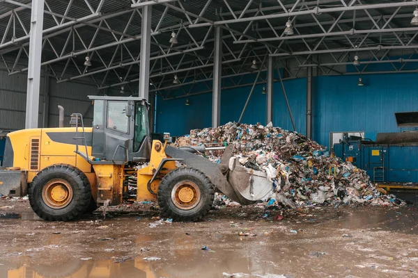 Speciální stroje nebo buldozer pracovat na místě odpadů vykládky v závodě pro likvidaci odpadů. — Stock fotografie