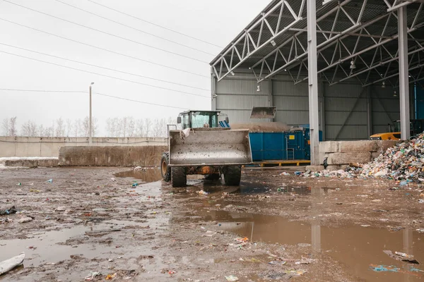 Speciella maskiner eller bulldozer fungerar på platsen av avfall lossning vid anläggningen för avfallshantering. — Stockfoto