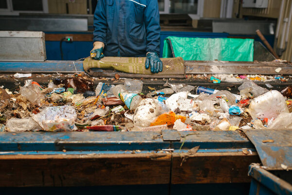 Waste sorting plant. Worker pre-sorts waste.