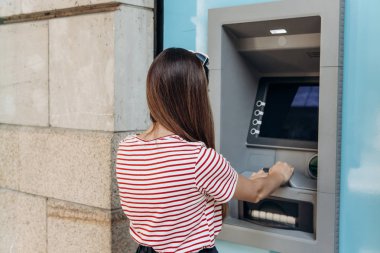 Genç bir kadın bir Atm. çekimden para Atm. finans, kredi kartı, para çekilmesi kartından alır..