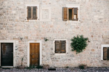 Bir kapı ve pencereler ile sıradan eski bir bina cephe.