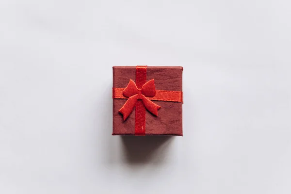 Caja roja con lazo con un regalo sobre fondo blanco —  Fotos de Stock