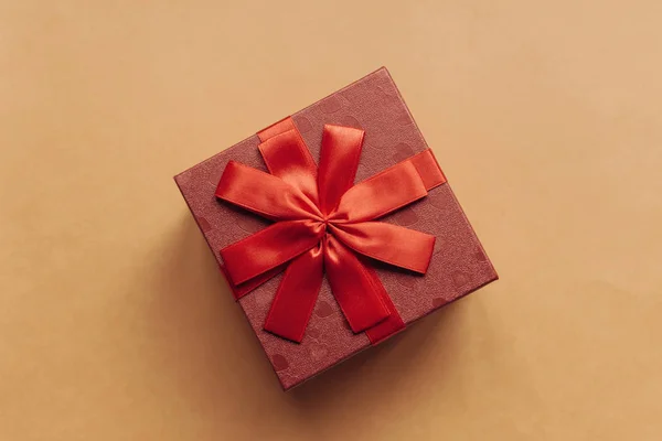 Czerwone pudełko z kokardą z prezentem na żółtym tle — Zdjęcie stockowe