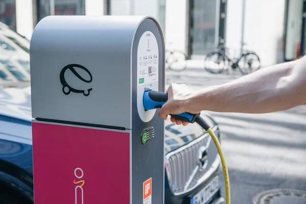 Street electric filling station for electric car refueling. Eco-friendly mode of transport. A person inserts a cord or cable to charge a car. — Stock Photo, Image