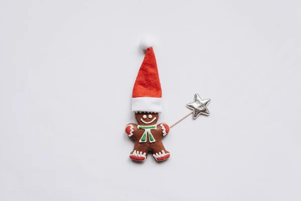Weihnachten Lebkuchen in Form eines kleinen Lebkuchenmännchens mit rotem Hut. — Stockfoto