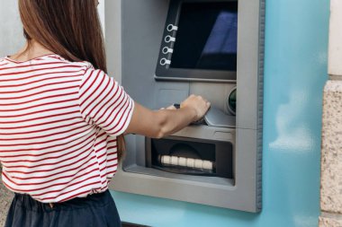 Genç bir kadın bir Atm. çekimden para Atm. finans, kredi kartı, para çekilmesi kartından alır..