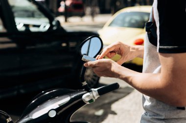 Bir adam ya da bir turist etkinleştirir veya bir mobil uygulaması bir cep telefonu kullanarak bir elektrikli scooter kiralar.