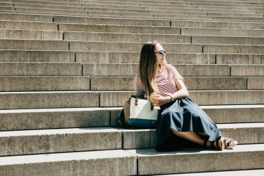 Üstünde belgili tanımlık merdiven ve dinlenirken güzel turist kız oturuyor.