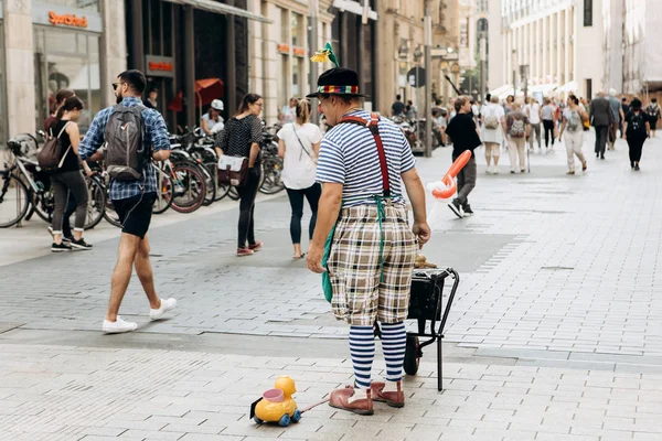 Un clown in una strada cittadina. Intrattenimento di turisti e locali . — Foto Stock