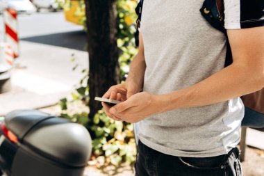 Bir turist ya da bir adam bir cep telefonu üzerinde bir şehir sokak kullanır