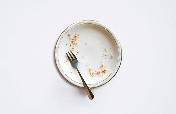 Empty plate with crumbs after eating on a white background. T — Stock Photo, Image