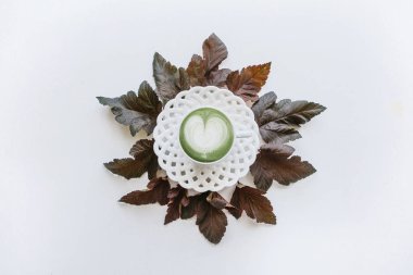 Taze yararlı yeşil matcha latte güzel bir kupa kahve. Yakındaki yalan sonbahar yaprakları.