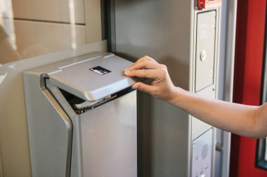 Özel bir çöp kutusuna bir tren gelen çöp atma yolcuların el yakın çekim.