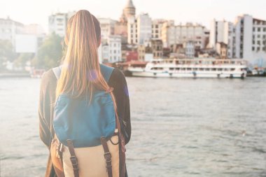 Günbatımında boğaz arka planda Istanbul 'un yanındaki genç turist kız.