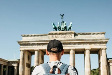 Bir turist veya Almanya'da Berlin Brandenburg Gate yakınındaki bir sırt çantası ile bir öğrenci.