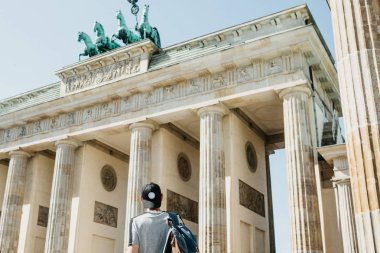 Bir turist veya Almanya'da Berlin Brandenburg Gate yakınındaki bir sırt çantası ile bir öğrenci.
