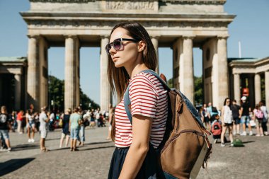 Bir turist ya da bir öğrenci de Almanya, Berlin Brandenburg Gate yakınındaki bir sırt çantası ile görünüyor manzaraları.
