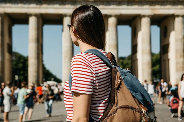 Jako turista nebo jako student s batohem u Braniborské brány v Berlíně v Německu, se dívá na památky. — Stock fotografie