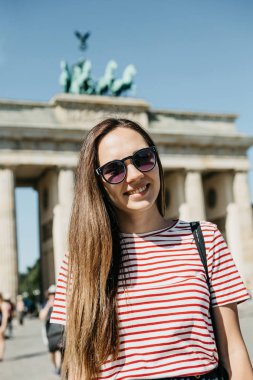 Genç güzel bir olumlu gülümseyen şık turist kız portresi.