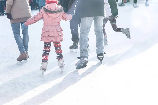 Vater und Tochter skaten in den Winterferien auf der Eisbahn. — Stockfoto