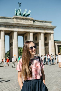 Genç güzel bir olumlu gülümseyen şık turist kız portresi.