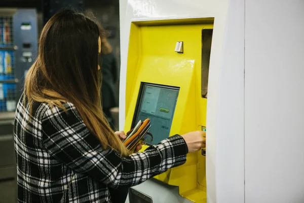 这个女孩用一台特殊的售票机在地铁上买票 — 图库照片