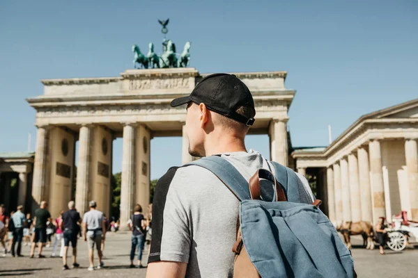 Een toerist of een student met een rugzak in de buurt van de Brandenburger Tor in Berlijn in Duitsland, kijkt naar de bezienswaardigheden. — Stockfoto