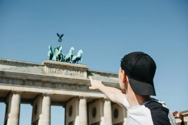 Turistické nebo chlap ukazuje ruku na Braniborská brána v Berlíně — Stock fotografie