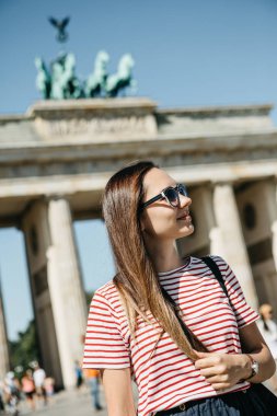 Genç güzel bir olumlu gülümseyen şık turist kız portresi.