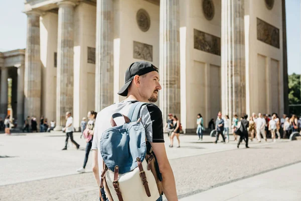 A tourist or a student with a backpack near the Brandenburg Gate in Berlin in Germany, looks at the sights. — Stock Photo, Image