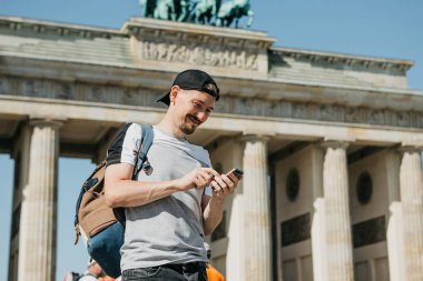 Bir turist ya da bir adam bir sırt çantası ile bir cep telefonu kullanır.