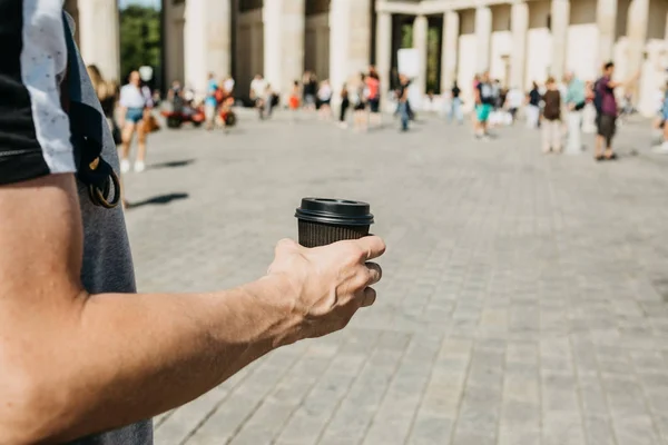 Closeup muže na ulici, drží v ruce kávu nebo jiný nápoj s sebou. — Stock fotografie