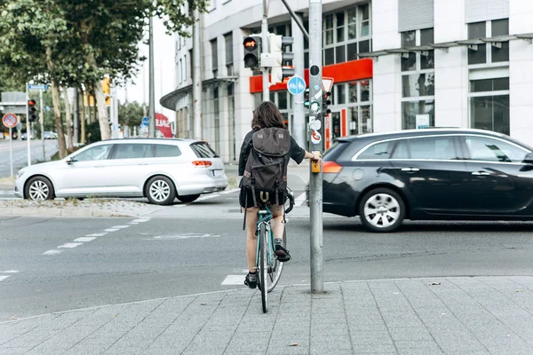Dziewczyna na rowerze zatrzymał się na czerwonym świetle i czekał, kiedy jechać. — Zdjęcie stockowe