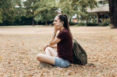 Bir cep telefonu üzerinde konuşurken güzel genç kız.