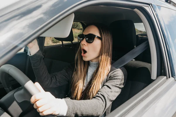 La chica o el conductor en el coche está sorprendido o asustado . — Foto de Stock