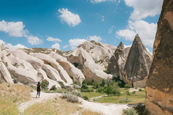 Una chica turística camina a lo largo de la carretera junto a las maravillosas colinas de Capadocia en Turquía y admira la belleza alrededor. El paisaje de Capadocia . — Foto de Stock