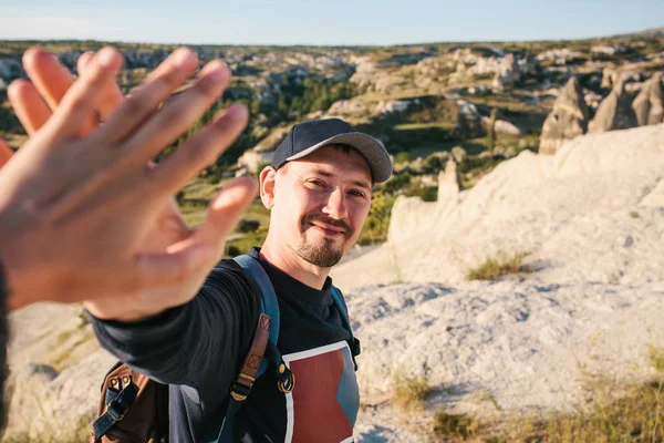 The tourist greet another tourist with a gesture of the hand. Hiking in the mountains