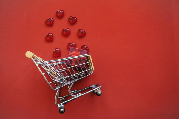 Shopping trolley with gift boxes and hearts. — Stock Photo, Image