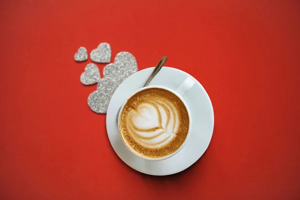 Fragante delicioso cappuccino sobre un fondo rojo . — Foto de Stock