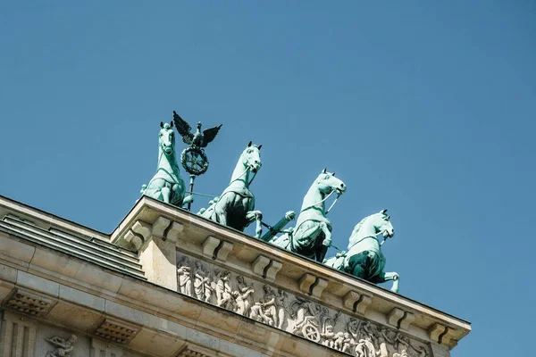 Closeup of the Brandenburg Gate against the blue sky.