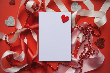 Şeritler, boncuk ve kalpleri ile şenlikli kırmızı arka plan.