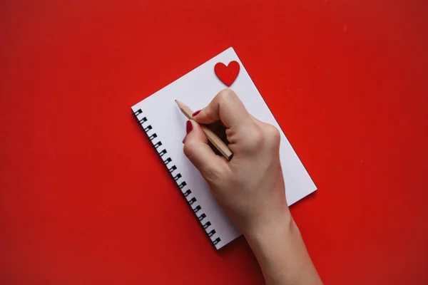 The girl writes congratulations or something else in a notebook. — Stock Photo, Image