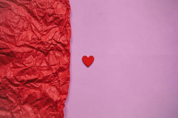 stock image Minimalistic concept for Valentines Day or another love event. Red small heart on a pink background.