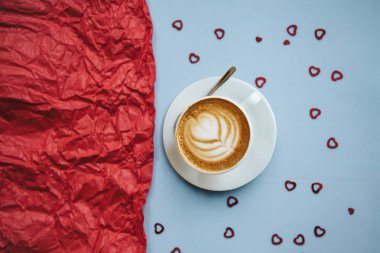 Bir fincan aromalı cappuccino kahve birçok kupa şenlikli bir zemin üzerine taze. Yanında kırmızı bir arka plan metni için bir yer vardır. Sevgililer günü veya kadın gün veya diğer aşk kutlama