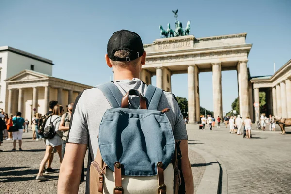 Een toerist of een student met een rugzak in de buurt van de Brandenburger Tor in Berlijn in Duitsland, kijkt naar de bezienswaardigheden. — Stockfoto