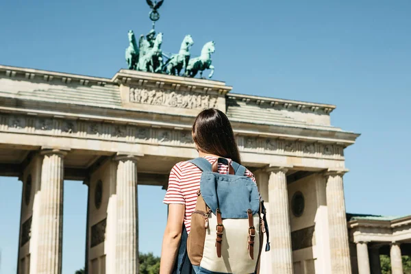 Een toerist of een student met een rugzak in de buurt van de Brandenburger Tor in Berlijn in Duitsland. — Stockfoto